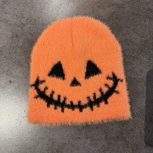 Close-up of fluffy orange knit beanie showing detailed faux mink fur and pumpkin face
