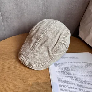 Dettaglio della trama del berretto piatto beige in lino lavato su un tavolo di legno