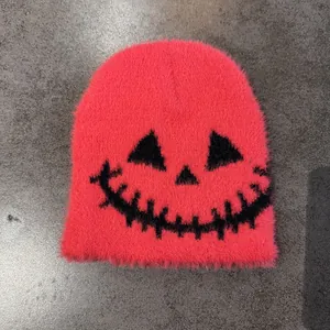 Detail of hot pink fuzzy knit beanie with funny black face design for Halloween