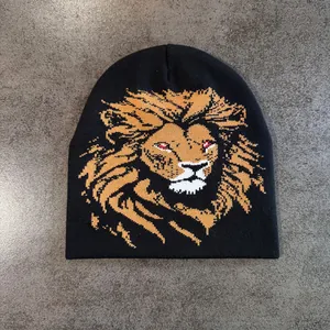 Détail de la maille d'un bonnet noir avec motif de lion brodé en orange et blanc