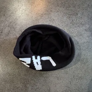Detailed view of black ribbed knit beanie featuring white LAZ lettering on texture