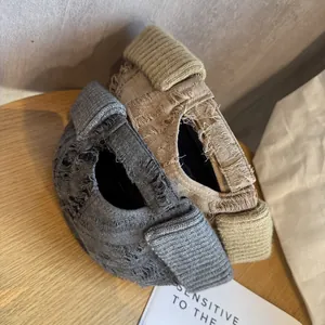Distressed vintage brimless dockers caps in dark grey and khaki on a wooden surface