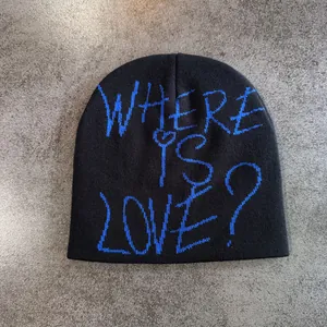 Vue de dessus d'un bonnet en maille noir avec texte bleu sur une surface grise