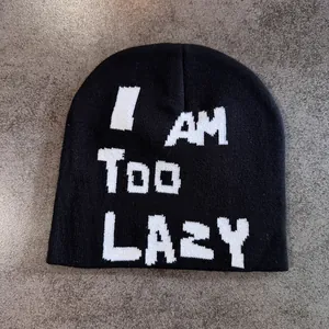 Detail of black knitted beanie featuring white I AM TOO LAZY text and soft fabric texture