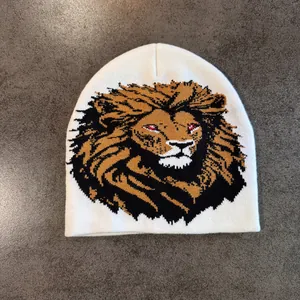 Détail macro de la broderie de lion et de la maille sur un bonnet blanc à rabats