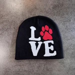 Detail shot of black knitted beanie featuring LOVE text and red paw print pattern