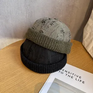 Detail of vintage distressed docker caps in black and army green with ripped crown design