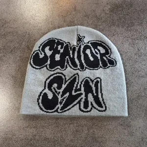 Détail du bonnet en maille grise avec texte jacquard SENIOR SZN noir et motifs étoiles