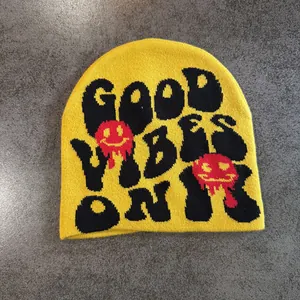 Gros plan du bonnet jaune avec texte Good Vibes Only et motifs de smileys fondus