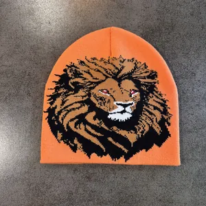 Gros plan détaillé du bonnet en maille orange vif avec un motif tissé de tête de lion