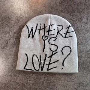 Texture détaillée d'un bonnet en maille avec inscription graffiti Where Is Love sur pierre