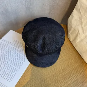 Detail view of deep blue newsboy cap with textured fabric and golden metal buckle