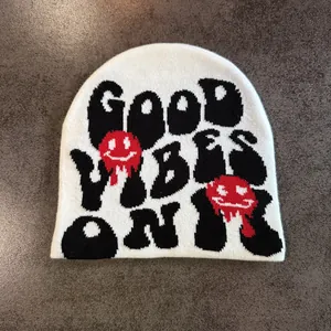 Détail du bonnet en tricot avec texte Good Vibes Only et smileys fondants