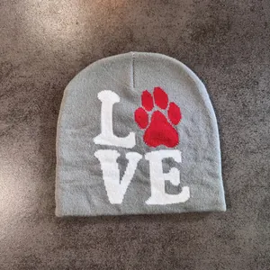 Close-up of grey knit beanie featuring white LOVE text and a red paw print design