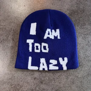 Detailed view of dark blue knit beanie featuring white I AM Too LAZY slogan embroidery