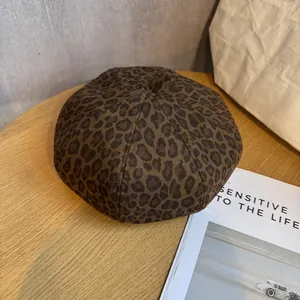 Detail of leopard print beret with thick autumn fabric texture on a wooden desk