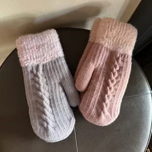 Détail de moufles en maille torsadée avec poignets en fourrure en rose et gris combinés