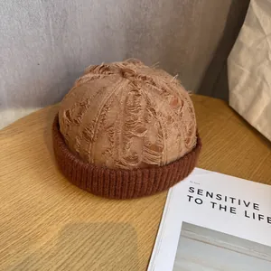 Close-up of vintage distressed miki hat featuring patchwork knit texture and frayed edges
