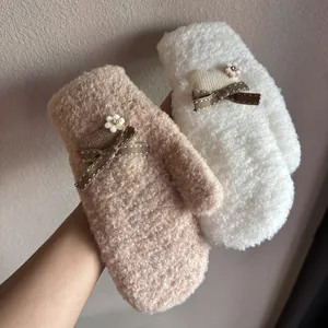 Detail von Plüschfäustlingen in Beige mit Strickherz, brauner Schleife und kleiner Blume