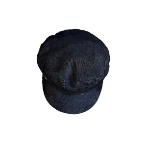 Retro dark blue newsboy cap with textured stripes and gold metal accent on white background