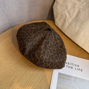Classic brown leopard print beret on a wooden table with a vintage aesthetic