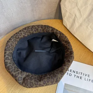 Vintage leopard print beret hat for women with thick plush texture on wooden table
