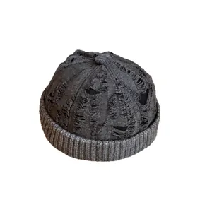 Distressed dark grey knit skull cap with vintage ripped details for street style