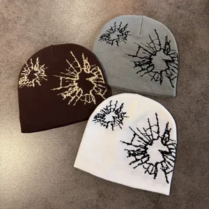 Three knitted beanies in brown, gray, and white with a stylish jacquard cracked pattern