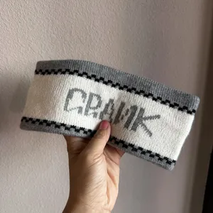 Detailed close-up of French jacquard knit headband with grey and white CRANK lettering