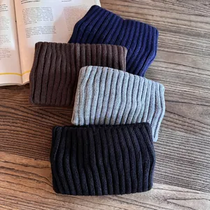 Solid knit wide headband in grey, black, brown and navy blue on a wooden desk
