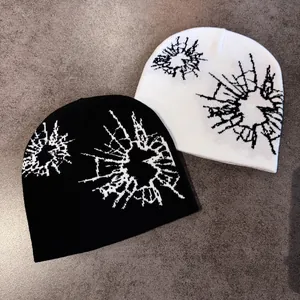 Winter knitted beanie hats in black and white with contrast abstract jacquard patterns