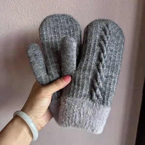 Détail de moufles en tricot gris avec motif torsadé et bordure en peluche aux poignets