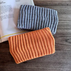 Minimalist winter knitted headband in orange and grey colors with ribbed texture