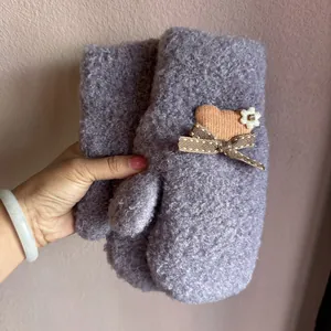 Detailansicht der lila Plüsch-Fäustlinge mit Herz- und Blumen-Dekormustern