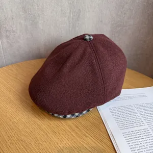 Close-up of wool flat cap with retro brown plaid lining and textured top button detail