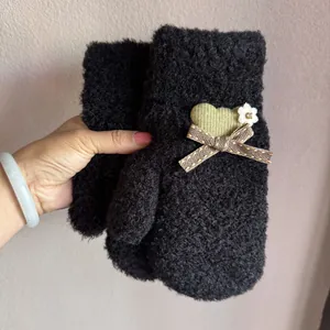 Details von warmen schwarzen Teddy-Fäustlingen mit Herz-Patch und Blumen-Schleifen-Dekor