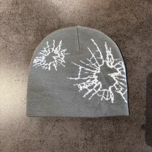Detail shot of the jacquard abstract geometric pattern on a gray knitted beanie hat