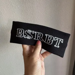 Close-up of black knitted elastic headband featuring white BSRBT letter embroidery