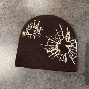 Flat lay of brown knit beanie featuring white geometric jacquard patterns on stone surface