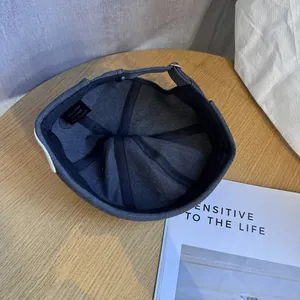 Détail de l'intérieur du bonnet docker gris montrant la bande et l'étiquette 100% coton