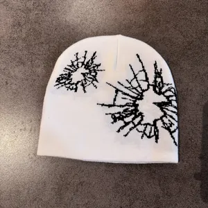 Detail shot of the thick knit texture and star-shaped pattern on this white winter beanie