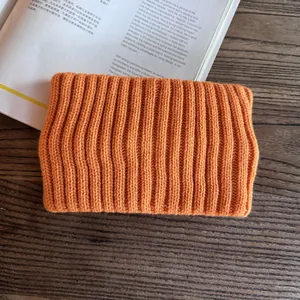 Detailed macro view of the bright orange ribbed knit texture and premium soft wool yarn