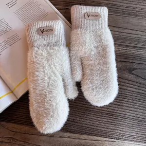 Detail of plush thermal gloves with elastic ribbed cuffs and embossed brand label