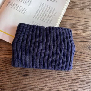 Detail of navy blue ribbed knit headband texture on a minimalist wooden background