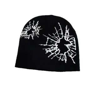 Unisex black knitted beanie with white abstract jacquard pattern for winter warmth