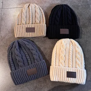 Dikke kabelgebreide mutsen in vier kleuren met leren patch voor winterwarmte