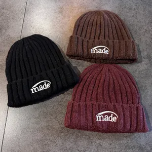 Trois bonnets en tricot brodés en noir, marron foncé et bordeaux avec lettrage made