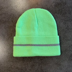 Detailed knit texture of fluorescent green beanie with grey reflective safety stripe