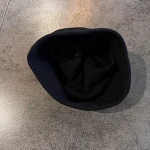 Close-up of the knitted texture and hem detail of a minimalist black beanie hat