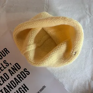 Detailed view of yellow chunky knit beanie texture and warm wool fabric stitching